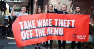 Hospo Voice members holding wage theft sign